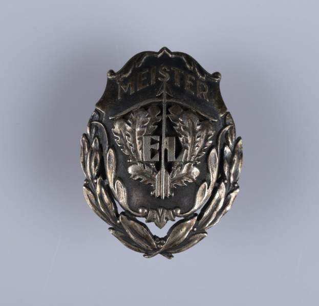 Ein silbernes deutsches Armeeabzeichen mit einem Lorbeerkranz und einer Inschrift in der Mitte.