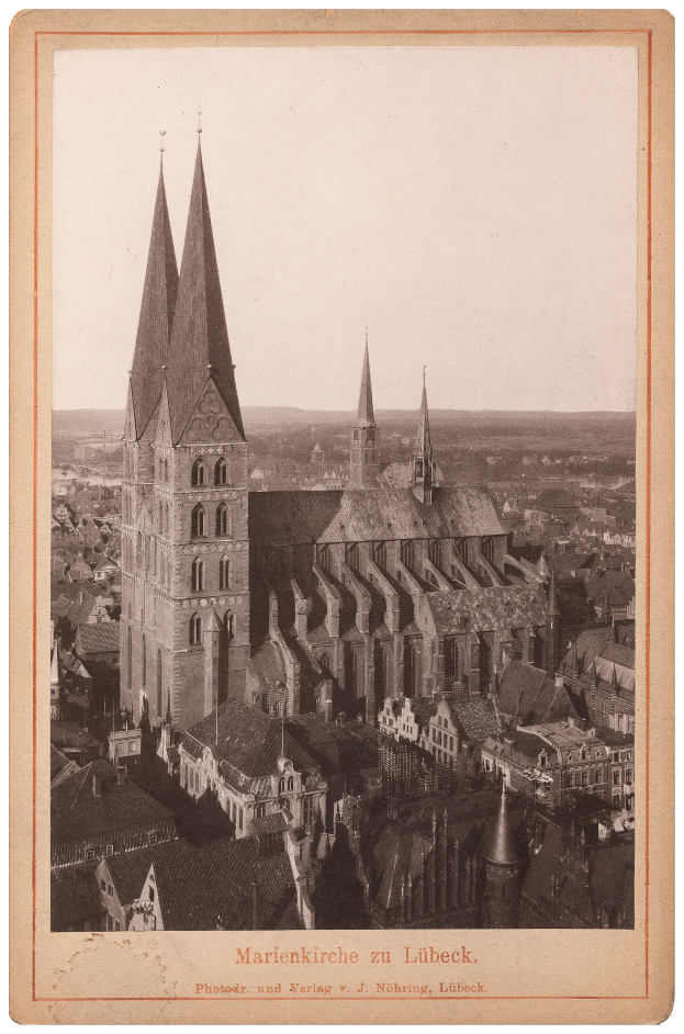 Ein altes Foto einer Stadt mit einer zentralen Kirche umgeben von anderen Gebäuden und Text am unteren Bildrand.