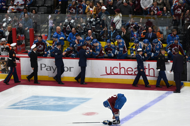 Ein Eishockeyspieler auf dem Eis umgeben von Fans und Teammitgliedern während eines Spiels von Colorado Avalanche gegen San Jose Sharks am 24. März 2015.