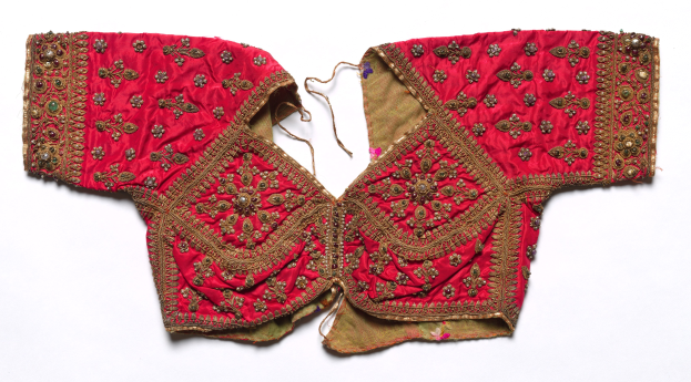 Rotes Oberteil mit goldener Stickerei mit detaillierten Designs, dargestellt auf einem weißen Hintergrund.