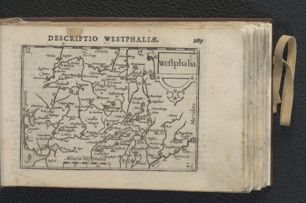 Offenes Buch mit detaillierter Westfalen-Karte auf schwarzer Oberfläche.