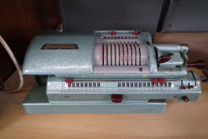 Alte Kasse auf einem Holztisch mit einem Draht an der linken Seite und Hintergrundobjekten.