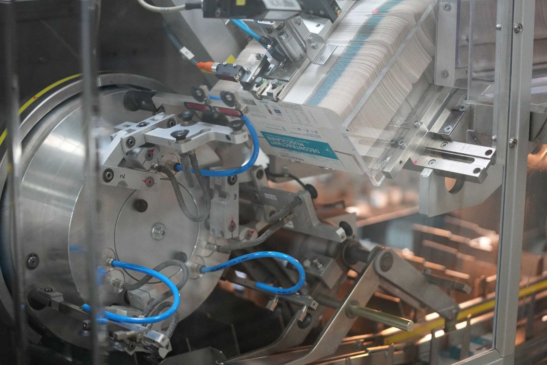 Automatisiertes Verpackungssystem auf einem Fabriktor mit leicht unscharfen Hintergrundobjekten.