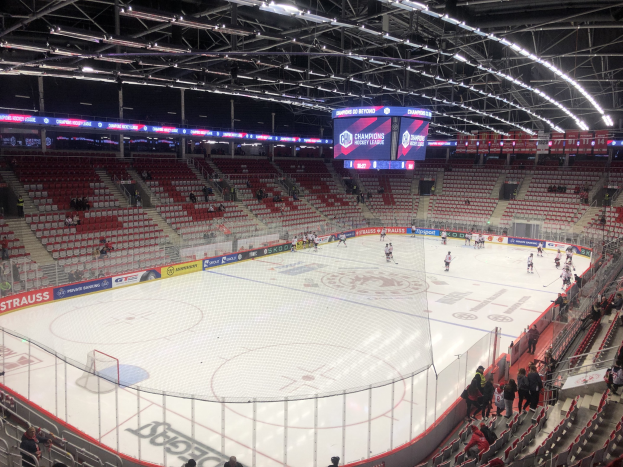 Eishockeyspiel in einer großen Arena zwischen den St. Louis Blues und Detroit Red Wings, mit Zuschauern auf den Sitzen und Stehplätzen in der Nähe des Spielfelds.
