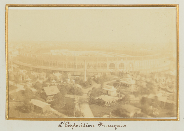 Altes Schwarz-Weiß-Foto eines Stadions in einer städtischen Umgebung, eingerahmt von Gebäuden, Bäumen und Strommasten, mit Text am unteren Rand.