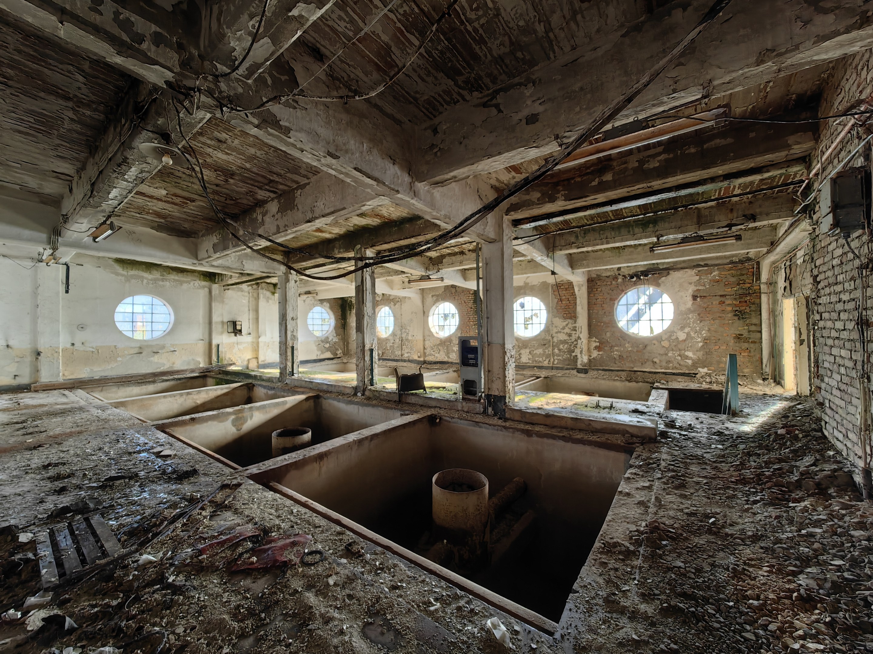 Verlassener Gebäuderaum im Chernobyl-Ausschlussgebiet mit verstreuten Trümmern, freiliegenden Wänden, Decke und konstruktiven Elementen.